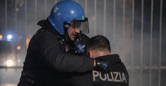 La foto finita sotto accusa dell'agente Alessandro soccorso da un collega, dopo l'aggressione da parte di un gruppo di manifestanti, durante gli scontri che hanno seguito il corteo contro lo sgombero del centro sociale Askatasuna. Torino, 1 febbraio 2026, ANSA/Ufficio stampa Polizia di Stato