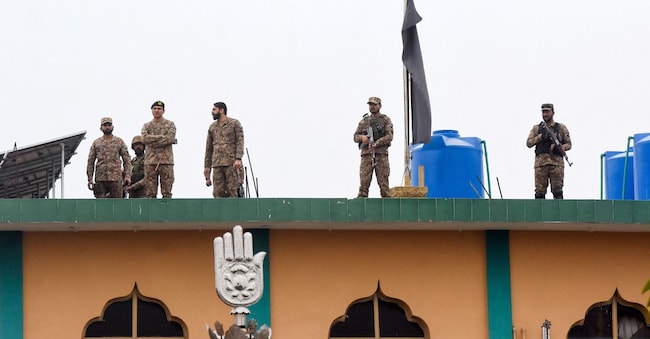 Pakistani soldiers stand guard on the roof of a Shiite mosque in Islamabad after a recent attack