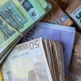 Bundles of European banknotes tied with rubber bands.
