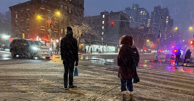 La gente aspetta di attraversare l'angolo tra la 20esima strada e la First Avenue durante una tempesta di neve, domenica 22 febbraio 2026, a New York. (AP Photo/Pamela Hassell)      Associated Press/ LaPresse Solo Italia e Spagna