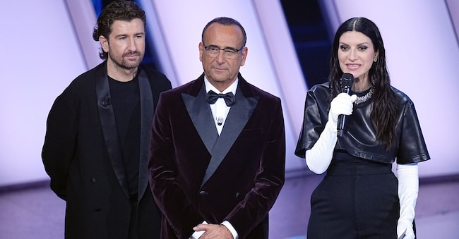 Alessandro Siani, Carlo Conti e Laura Pausini sul palco durante la serata delle cover di Sanremo 2026