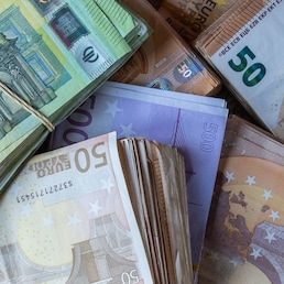 Bundles of European banknotes tied with rubber bands.