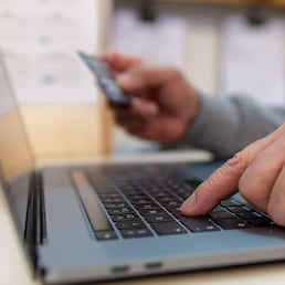 A person using a payment card to pay online.