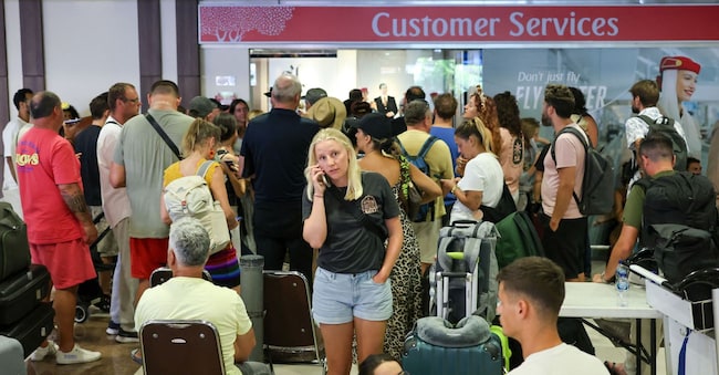 Passeggeri bloccati attendono vicino all'ufficio del servizio clienti della Emirates Airways all'aeroporto internazionale I Gusti Ngurah Rai dopo che i voli per Doha, Dubai e Abu Dhabi sono stati cancellati a seguito degli attacchi contro l'Iran lanciati dagli Stati Uniti e da Israele. REUTERS/Johannes Christo
