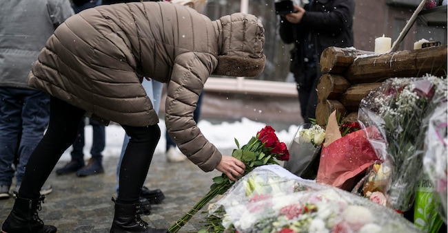 epa12737583 Una persona in lutto depone dei fiori davanti al bar "Le Constellation" a Crans-Montana per commemorare le vittime del mortale incendio che ha colpito il locale, Crans-Montana, Svizzera, 14 febbraio 2026.   EPA/ALESSANDRO DELLA VALLE