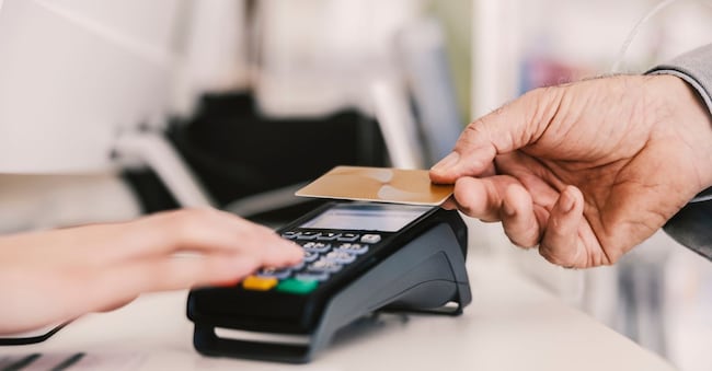 Close up of old man paying with credit card on pos terminal.