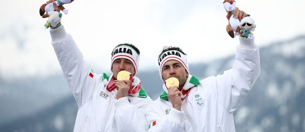 Paralimpiadi Milano Cortina 2026 - Sci alpino paralimpico - Combinata alpina maschile per ipovedenti Cerimonia di premiazione - Centro sciistico Tofane, Belluno, Italia - 10 marzo 2026.  Il medaglia d'oro Giacomo Bertagnolli (Italia) e la sua guida Andrea Ravelli (Italia) festeggiano sul podio dopo aver vinto la gara di combinata alpina slalom per ipovedenti. REUTERS/Stoyan Nenov