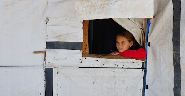 Una bambina osserva un campo di tende dove hanno trovato rifugio i palestinesi sfollati durante i due anni di offensiva israeliana, a Deir al-Balah, nella Striscia di Gaza centrale, l'11 marzo 2026. REUTERS/Mahmoud Issa