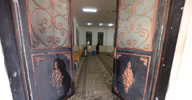 Un palesinese al lavoro per ripulire la moschea di Duma dopo gli atti vandalici e il tentativo di incendio.  EPA/ALAA BADARNEH