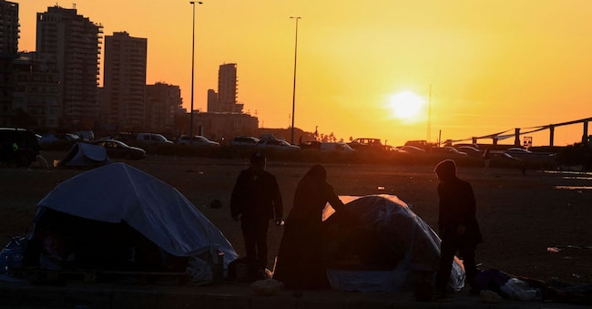 Uno sfollato copre una tenda con un telo di plastica per ripararla dalla pioggia, in seguito all'escalation tra Hezbollah e Israele, nel contesto del conflitto tra Stati Uniti e Israele con l'Iran, a Beirut, in Libano, il 17 marzo 2026. REUTERS/Mohamed Azakir