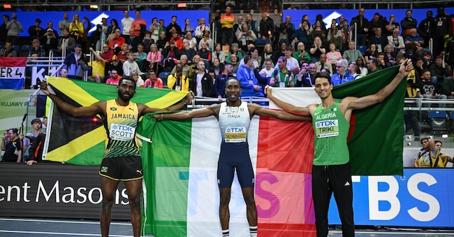 Il giamaicano Jordan Scott, medaglia d'argento, l'italiano Andy Diaz Hernandez, medaglia d'oro, e l'algerino Yasser Triki, medaglia di bronzo, posano per una foto dopo la finale del salto triplo maschile ai Campionati mondiali di atletica leggera indoor alla Kujawsko-Pomorska Arena di Toruń, in Polonia, il 20 marzo 2026.  EPA/Adam Warzawa POLONIA OUT EPA