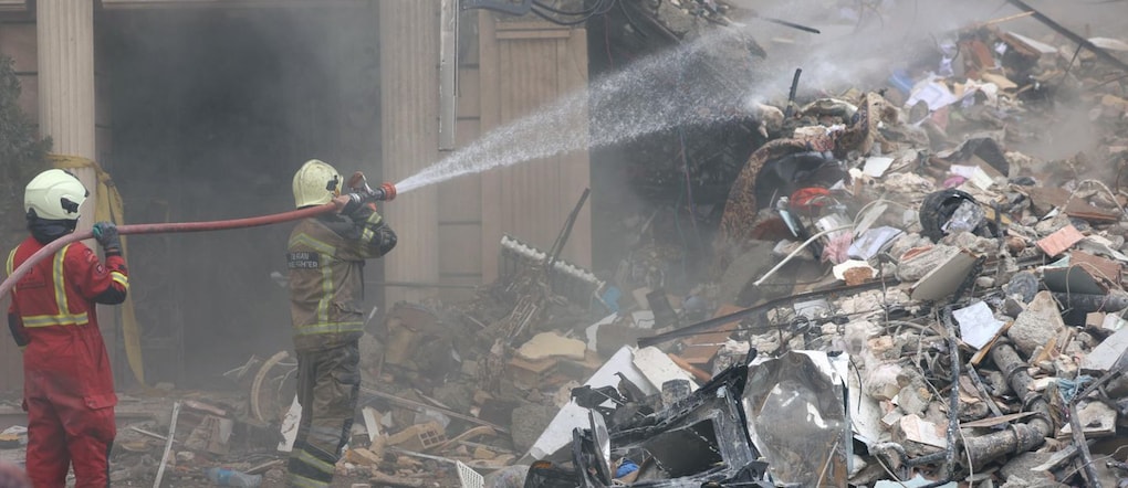 I vigili del fuoco e i funzionari iraniani sono al lavoro sul luogo dove si trovano gli edifici residenziali danneggiati nella zona nord di Teheran, in Iran, il 23 marzo 2026. Un'operazione militare congiunta tra Israele e Stati Uniti continua a colpire diverse località in tutto l'Iran sin dalle prime ore del 28 febbraio 2026.  EPA/ABEDIN TAHERKENAREH EPA