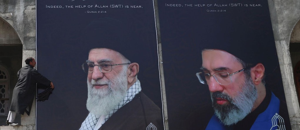 Un uomo pulisce un cartellone pubblicitario raffigurante il nuovo leader supremo dell'Iran, l'ayatollah Mojtaba Khamenei (a destra), e il defunto leader supremo dell'Iran, l'ayatollah Ruhollah Khomeini (a sinistra), alla periferia di Srinagar, nel Kashmir (India), il 24 marzo 2026. I membri della comunità sciita locale hanno continuato a raccogliere fondi e aiuti umanitari per le persone in Iran colpite dal conflitto in corso che coinvolge l'Iran, Israele e gli Stati Uniti. Reuters e altre recenti notizie descrivono Mojtaba Khamenei come colui che ha assunto formalmente il ruolo di leader supremo questo mese.  EPA/FAROOQ KHAN EPA