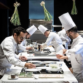 (FILES) Michelin three-star chef Cesar Troisgros (L) cooks at his hotel-restaurant "Le Bois sans Feuilles" in Ouches on June 9, 2023. French chef Cesar Troisgros, heir to a renowned family lineage and at the helm of Le Bois Sans Feuilles restaurant in Ouches, was crowned Chef of the Year 2026 by the Gault et Millau guide on November 17, 2025. (Photo by JEAN-PHILIPPE KSIAZEK / AFP) AFP