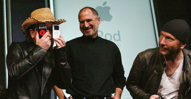 Il cantante degli U2, Bono, scherza mentre posa insieme al CEO di Apple Steve Jobs e al chitarrista degli U2 The Edge durante la presentazione dell’iPod U2 Special Edition a San Jose nel 2004./Foto d'archivio REUTERS