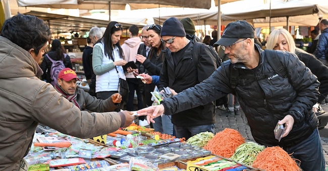 Turisti fanno acquisti in una bancarella a Campo de Fiori,  Roma ANSA