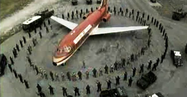 Il Boeing 737 dell'Egypt Air dirottato da quattro terroristi palestinesi circondato dalle forze americane sulla pista, a loro volta circondate dalle forze speciali dei carabinieri, nell'iconica immagine scattata da un carabiniere l'11 ottobre 1985 nella base di Sigonella. ANSA