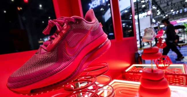 FILE PHOTO: A man walks past Nike booth with installation of shoes at the 8th China International Import Expo (CIIE) venue in Shanghai, China, November 5, 2025. REUTERS/Maxim Shemetov/File Photo REUTERS
