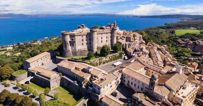Medieval castles of Italy - Castello Orsini-Odescalchi in Bracciano town and lake. Aerial drone view. Lazio region