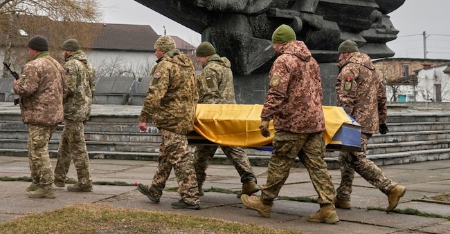 Mercoledì 18 marzo 2026, nel villaggio di Novi Petrivtsi, vicino alla capitale Kiev, in Ucraina, durante il corteo funebre, alcuni militari trasportano la bara del soldato volontario ventenne Dmytro Dukhota, caduto in battaglia contro le truppe russe, davanti al monumento dedicato alla Seconda guerra mondiale. (AP Photo/Efrem Lukatsky) APN