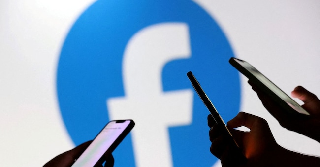 FILE PHOTO: Teenagers pose for a photo while holding smartphones in front of a Facebook logo in this illustration taken September 11, 2025. REUTERS/Dado Ruvic/Illustration/File Photo REUTERS