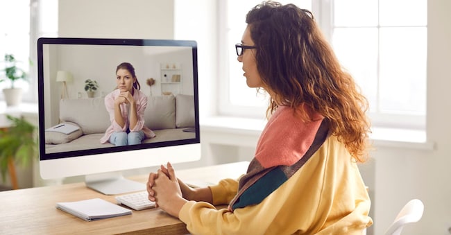 Un terapeuta o uno psicologo professionista offre una consulenza video tramite una videoconferenza in webcam sul computer e aiuta una giovane paziente a comprendere se stessa. Terapia online, concetto di psicoterapia Studio Romantic - stock.adobe.com