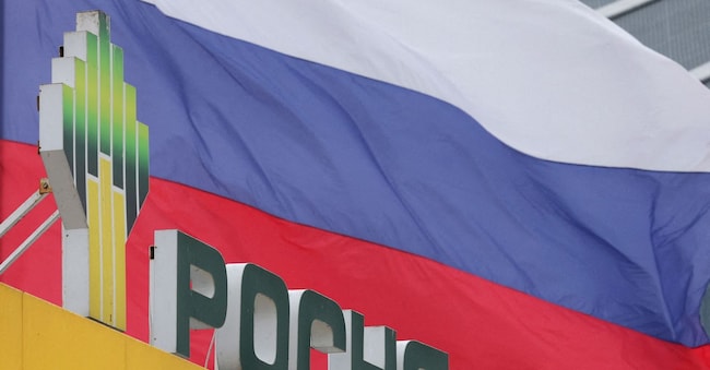  La bandiera nazionale russa sventola dietro un cartello con il logo della compagnia petrolifera Rosneft, installato presso una stazione di servizio a San Pietroburgo, in Russia REUTERS