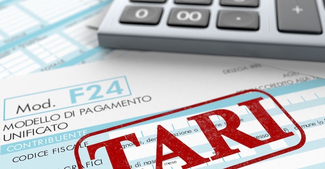 close up view of F24 form for italian taxes,the word tari and an electronic calculator (3d render) lucadp - stock.adobe.com