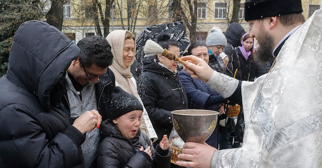 Un sacerdote benedice i fedeli e i loro cesti contenenti uova dipinte e dolci pasquali tradizionali, nei pressi della Cattedrale di San Volodymyr a Kiev, in Ucraina, l'11 aprile 2026, alla vigilia della celebrazione della Pasqua ortodossa. I fedeli ucraini celebrano la Pasqua il 12 aprile 2026, mentre è in corso l'invasione russa.  EPA/SERGEY DOLZHENKO EPA