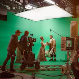 On Big Film Studio Professional Crew Shooting History Costume Drama Movie. On Set: Director Controls Cameraman Shooting Green Screen Scene with Two Actors Talented Wearing Renaissance Clothes Talking Gorodenkoff - stock.adobe.com