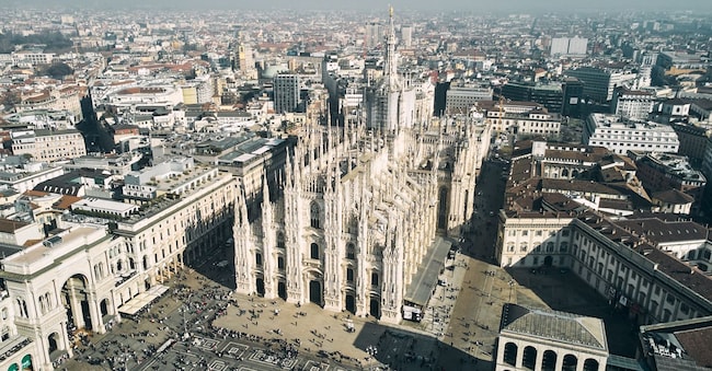 Aerial view of Piazza Duomo in front of the gothic cathedral in the center. Drone view of the gallery and rooftops during the day. Milan, Italy. High quality photo Dima Anikin - stock.adobe.com