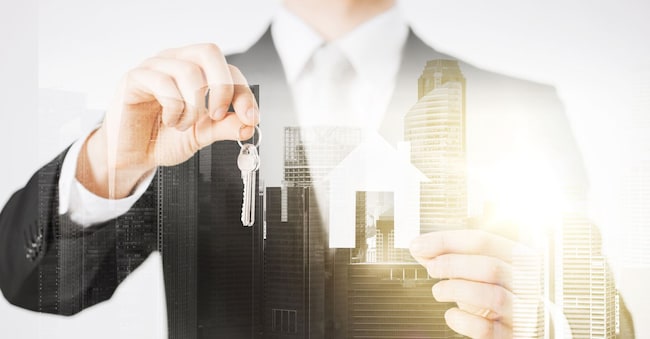 business, people and mortgage concept - close up of businessman holding keys and paper house over city with double exposure