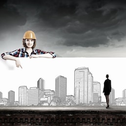 Young woman builder wearing helmet and holding banner with construction sketches