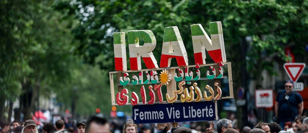 Una manifestante tiene in mano un cartello fatto a mano con le lettere che compongono la parola «Iran», durante la tradizionale marcia sindacale del Primo Maggio a Parigi, in Francia, il 1° maggio 2026. Lo slogan recita: «Donna, vita, libertà». REUTERS/Benoit Tessier REUTERS