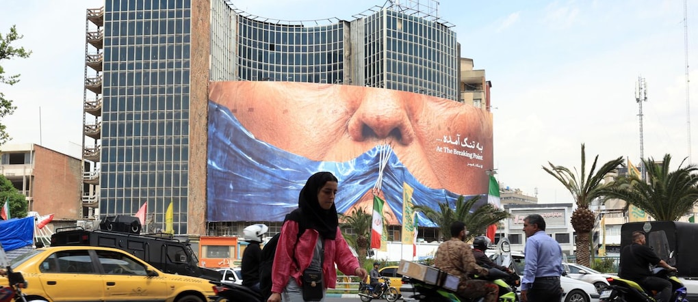 Alcuni iraniani passano davanti a un enorme cartellone pubblicitario anti-statunitense che fa riferimento al presidente degli Stati Uniti Donald Trump e allo Stretto di Hormuz in piazza Valiasr a Teheran, in Iran, il 2 maggio 2026. Il conflitto tra l'Iran e gli Stati Uniti sullo Stretto di Hormuz continua, poiché la tregua tra i due paesi è stata prorogata a tempo indeterminato e sono in corso negoziati diplomatici.  EPA/ABEDIN TAHERKENAREH EPA