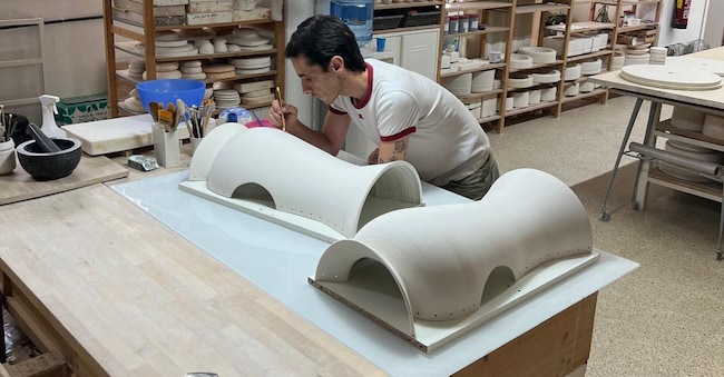 L’artista Daniel del Valle durante la realizzazione di un bustier a forma di vaso in ceramica bianco.
