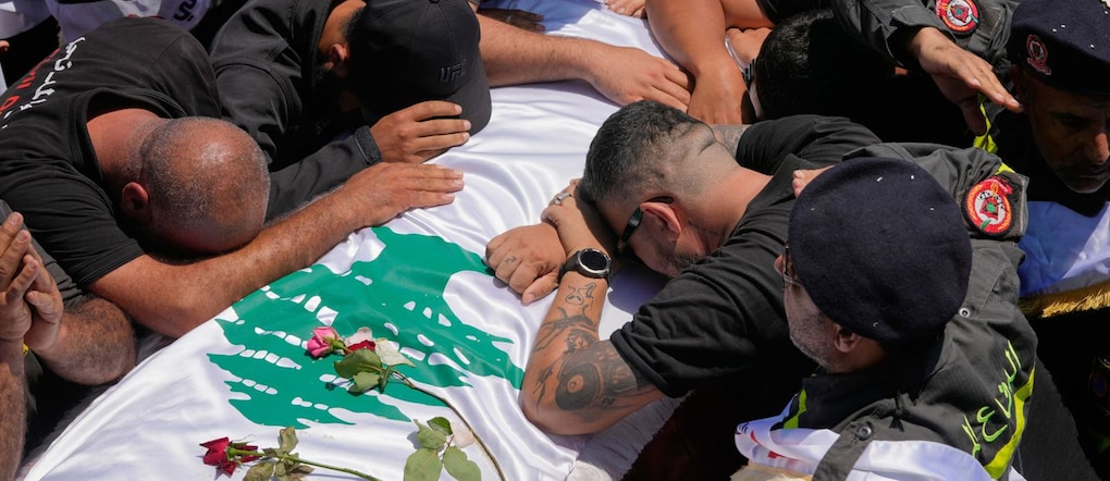 I membri della Protezione Civile libanese e i partecipanti al funerale si radunano attorno alle bare dei tre colleghi uccisi martedì in un attacco israeliano, durante il corteo funebre nella città portuale meridionale di Tiro, in Libano, giovedì 30 aprile 2026. (AP Photo/Hussein Malla) APN
