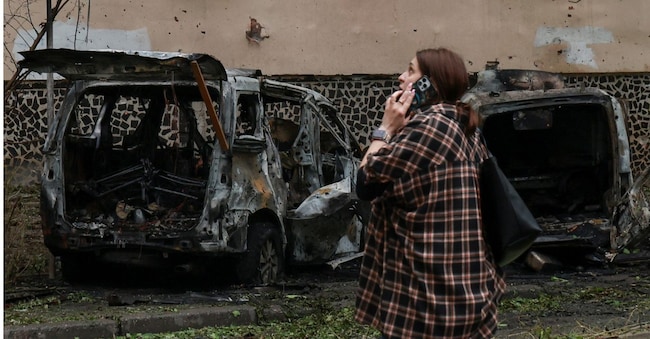 Un residente parla al telefono accanto ad alcune auto bruciate nel luogo in cui un condominio è stato danneggiato durante un attacco con droni russi, nel contesto dell'offensiva russa contro l'Ucraina, a Odessa, Ucraina, il 13 maggio 2026. REUTERS/Nina Liashonok REUTERS