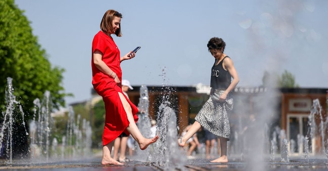 A Mosca, in Russia, il 22 maggio 2026, alcune donne camminano a piedi nudi in una fontana per rinfrescarsi in una giornata torrida, con temperature che raggiungono i 30 gradi Celsius (86 gradi Fahrenheit). REUTERS/Ramil Sitdikov REUTERS