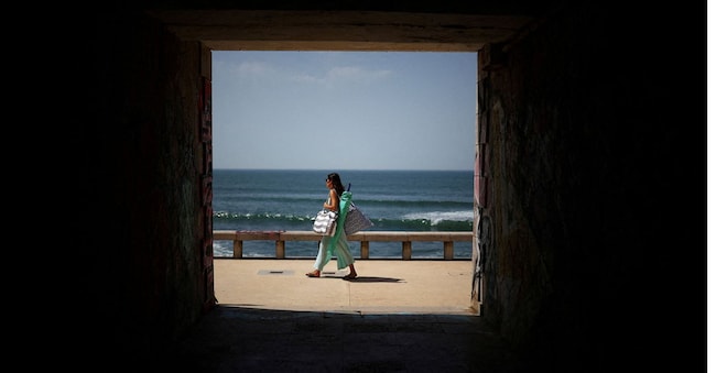 Una persona arriva alla spiaggia di Parede, mentre le temperature raggiungono livelli elevati a Cascais, il 26 maggio 2026. REUTERS/Pedro Nunes     IMMAGINI DEL GIORNO DI TPX REUTERS