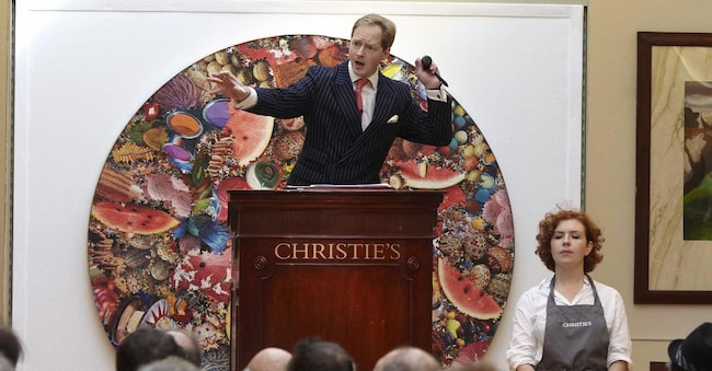 Il banditore Nick Martineau sul podio, circondato dalle opere d'arte. (Fotografo: Rupert Hartley/Bloomberg)