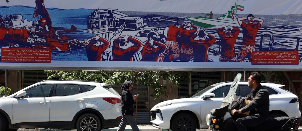 Alcuni iraniani camminano accanto a un cartellone pubblicitario anti-statunitense nei pressi dell'ex ambasciata degli Stati Uniti a Teheran, in Iran, il 26 maggio 2026. Il presidente degli Stati Uniti Donald Trump ha annunciato che un potenziale accordo di pace per porre fine al conflitto e riaprire lo Stretto di Ormuz è stato in gran parte negoziato tramite mediatori pakistani. Tuttavia, gli Stati Uniti hanno sferrato nuovi attacchi nel sud dell'Iran.  EPA/ABEDIN TAHERKENAREH EPA