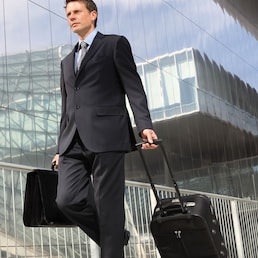 businessman walking with trolley and bag, business travel amedeoemaja - stock.adobe.com
