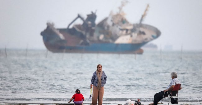 People gather on a beach, as a vessel in the Strait of Hormuz is visible, near the beach of Bandar Abbas, Iran, May 31, 2026.  Amirhosein Khorgooi/ISNA/WANA (West Asia News Agency) via REUTERS ATTENTION EDITORS  via REUTERS