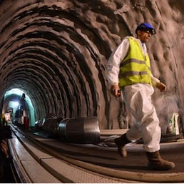 A worker walks inside the tunnel boring machine of the new high-speed TAV rail line in the Chiomonte tunnel on November 12,2013. The high-speed rail link between Turin-Lyon is considered a key element of a planned network of high-speed railways across Europe and is expected to cost an estimated 12.5 billion euros (15 billion US dollars) and be completed by 2020. AFP PHOTO / GIUSEPPE CACACE AFP