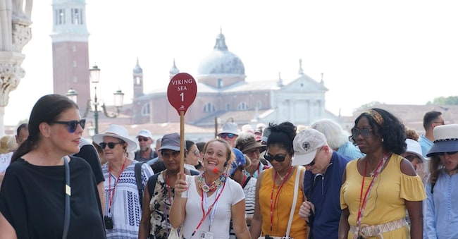 Una guida turistica accompagna un gruppo di visitatori verso piazza San Marco, usando un radio microfono per comunicare con loro, Venezia, 1 agosto 2024. ANSA/ANDREA MEROLA ANSA