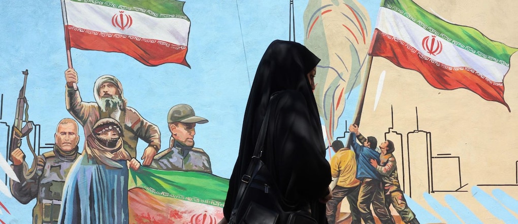 Una passante nelle strade di Teheran. Nella notte gli Usa sono tornati ad attaccare l’Iran in risposta all’abbattimento di un loro elicottero nei pressi dello Stretto di Hormuz EPA