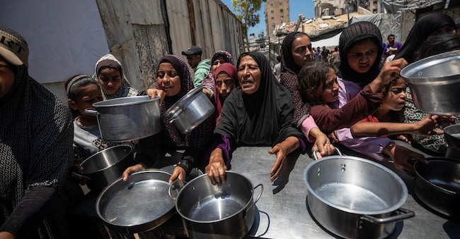 epa13027909 Profughi palestinesi con pentole e padelle di metallo in mano mentre si radunano per ricevere pasti caldi da una mensa di beneficenza nella parte settentrionale della città di Gaza, 10 giugno 2026. La distribuzione di cibo è avvenuta in un momento di grave carenza di aiuti di prima necessità in tutta l'enclave. Le agenzie delle Nazioni Unite hanno riferito che, nonostante un cessate il fuoco nominale, l'ingresso di aiuti essenziali a Gaza rimane fortemente limitato. EPA/MOHAMMED SABER EPA