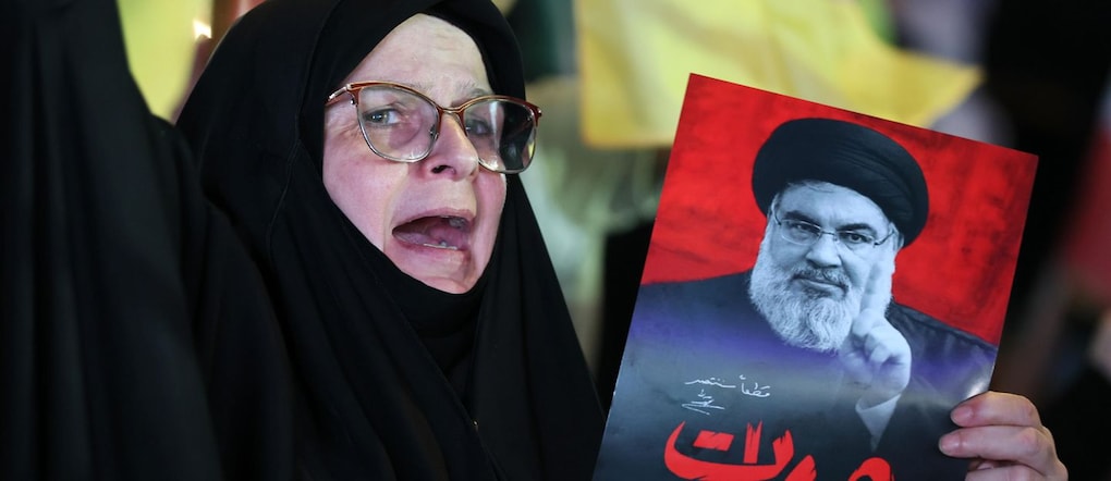 Una sostenitrice di Hezbollah porta una foto del defunto leader dell'organizzazione Hassan Nasrallah EPA