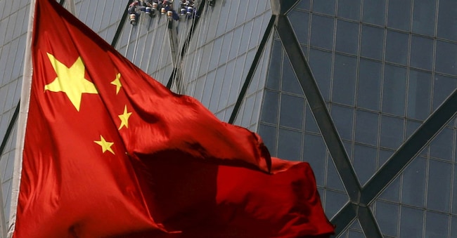 La bandiera nazionale Cinese sventola davanti a un distretto commerciale a Pechino REUTERS